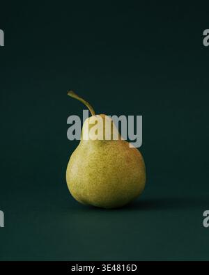 Frische Birne auf grünem Hintergrund. Minimales gesundes Lebensmittelkonzept mit Kopierraum. Trendige Frucht-Idee. Stockfoto