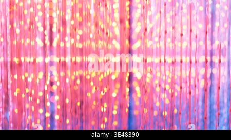 Leuchtende rosa und gelbe Bokeh-Lichter schaffen einen abstrakten festlichen Hintergrund Stockfoto
