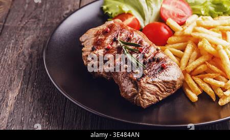 New York Steak mit Pommes frites und Salat. Stockfoto