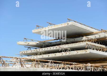 Gestapelte filigrane Betonfertigteile, die auf einer Baustelle gelagert werden und als Boden- oder Deckenelemente in moderner Gebäudekonstruktion einbaufertig sind Stockfoto