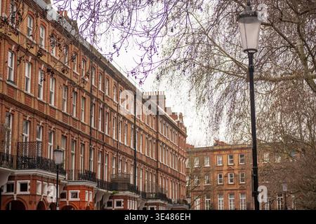 LONDON - 2. FEBRUAR 2026: Stadthäuser im georgianischen Stil aus roten Backsteinen mit Balkonen in Earl's Court SW5 Stockfoto