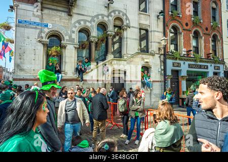 St Patrick's Day Dublin 2026. Die Leute sitzen in den Fenstern und tragen grün am Foggy Dew Pub in der Fownes Street für die Parade am 17. März. Stockfoto