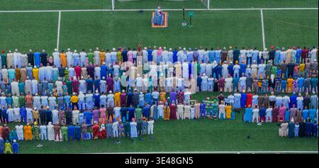 Lagos, Nigeria - 20. März 2026: Luftaufnahme einer Vielzahl von Menschen, ein Meer aus leuchtenden Gewändern und Kopfbedeckungen, vereint im Gebet auf einem üppig grünen Fall Stockfoto