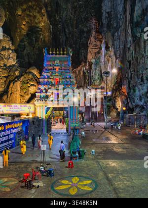 Kuala Lumpur, Malaysia - 18. Februar 2025: Der lebendige TEMPEL SRI VELAYUTHAR Haupttempel beleuchtet in den Batu-Höhlen, mit Besuchern und komplizierten Details Stockfoto