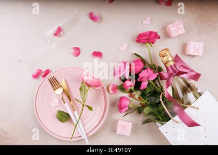 Elegante romantische Tischaufstellung mit rosa Rosen und Sektflasche Stockfoto