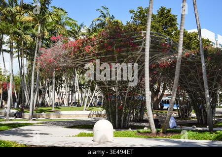 Moderner tropischer Park mit Palmen und blühender Pergola Stockfoto