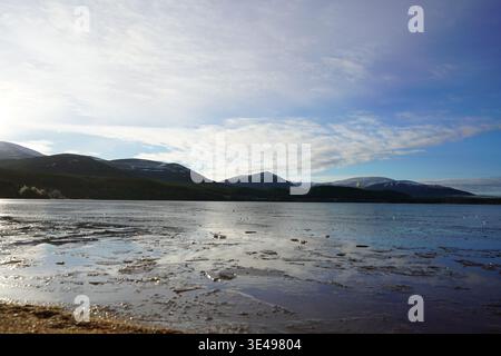 Winterblick über Loch Morlich mit den schneebedeckten Cairngorm Mountains in den schottischen Highlands Stockfoto