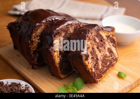 Köstlicher Marmor-Schokoladenkuchen mit glänzender Ganache und frischer Minzgarnitur Stockfoto