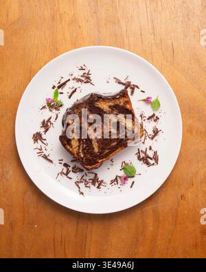 Köstlicher Marmor-Schokoladenkuchen mit glänzender Ganache und frischer Minzgarnitur Stockfoto