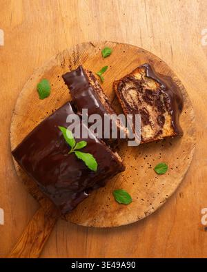 Köstlicher Marmor-Schokoladenkuchen mit glänzender Ganache und frischer Minzgarnitur Stockfoto
