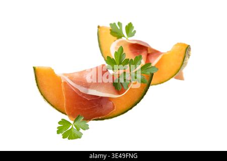 Traditionelle spanische Jamonscheibe (getrocknetes Schweinefleisch) mit Orangenmelone ( cucumis melo) und frischen Petersilienblättern auf weißem Hintergrund Stockfoto