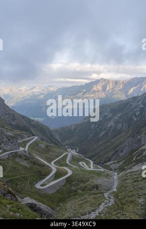 Haarnadelkurven der Bergstraße, die in ein tiefes Tal in der Schweiz hinabführt Stockfoto