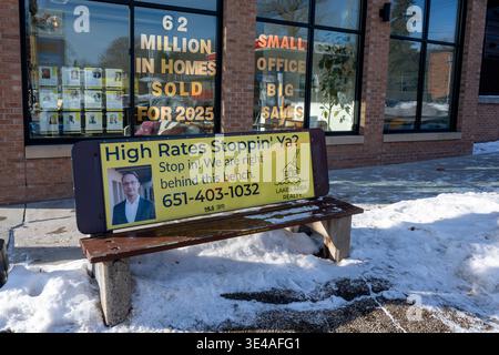 St. Paul, Minnesota. Immobilienmakler, der Hausverkäufe auf der Bank vor dem Bürogebäude anbietet. Stockfoto