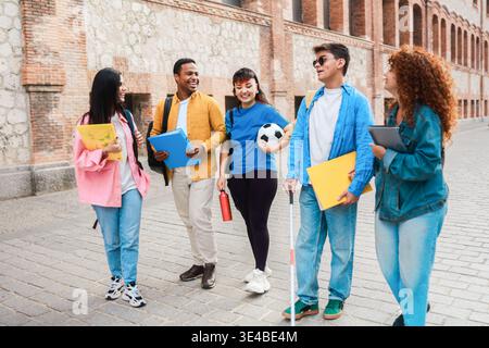 Student mit Behinderung, der Spaß mit Freunden außerhalb der Campus-Universität hat - Fokus auf Blindengesicht Stockfoto