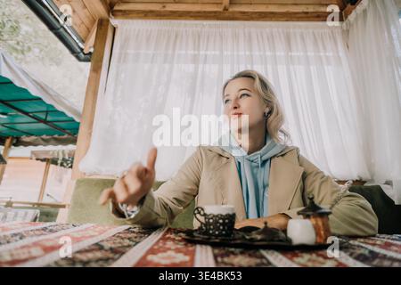 Eine junge Frau genießt türkischen Kaffee in einem gemütlichen Café Stockfoto