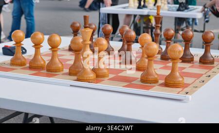 Hölzerne Schachfiguren auf einem Brett, bereit für ein strategisches Outdoor-Spiel Stockfoto