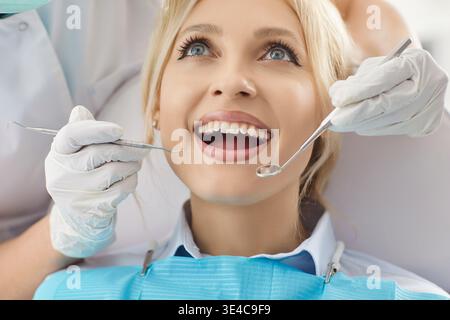 Nahaufnahme einer jungen Frau, die den Mund weit geöffnet hält, um Zähne in der Zahnklinik zu heilen Stockfoto