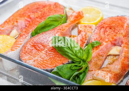 Lachs. Frisches rotes Lachs-Filet-Steak mit Kochzutaten auf Glashintergrund, Draufsicht. Stockfoto