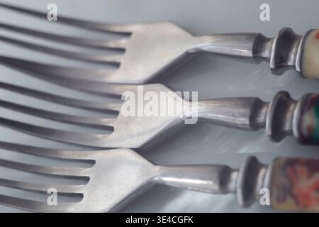 Nahaufnahme von drei Vintage-sowjetischen Gabeln mit markantem Rhythmus und Schwerpunkt auf den geschwungenen Hälsen Stockfoto
