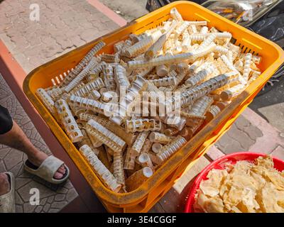 Eine gelbe Plastikkiste gefüllt mit getrocknetem, röhrenförmigem Fischskelett, Knorpel, Knochen und einem roten Korb mit getrocknetem Fischkreb in einer indonesischen Straße mar Stockfoto