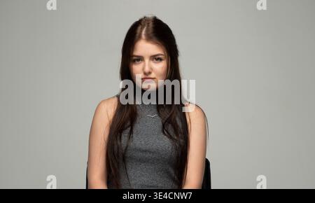 Junge Frau, die traurig ist, Enttäuschung und emotionale Not in einem Atelierporträt zeigt Stockfoto