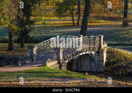 Alte Metallbrücke im Gatchina Palace Park an einem sonnigen Oktobernachmittag. Oblast Leningrad, Russland Stockfoto