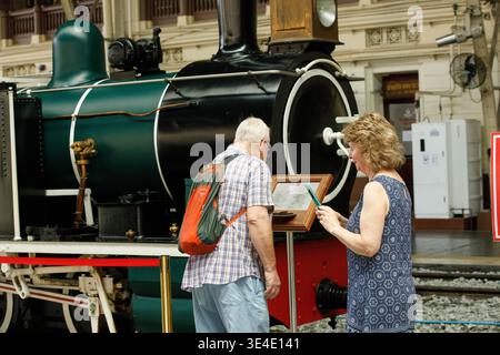 BANGKOK, THAILAND, 15. März 2026: Seniorenpaar studiert Geschichte der thailändischen Eisenbahn, Reisende entdecken ein neues Ziel, Rückansicht, in Hua Lamphong. Stockfoto