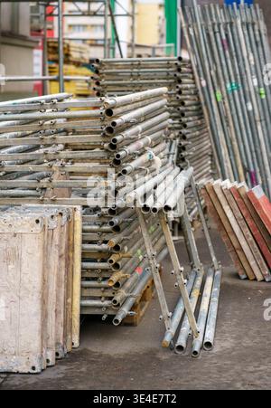 Gestapelte Gerüstrohre aus Metall auf der Baustelle, Baumaterialien, Industrieanlagen, Ingenieurwesen, Renovierung und Entwicklungskonzept Stockfoto