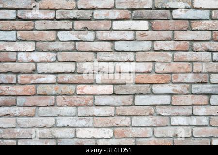 Wandfläche aus antikem Backstein, architektonische Details für Innen- oder Außendesign. Mehrfarbige alte Backsteinwand Hintergrund, rustikaler Stil. Stockfoto