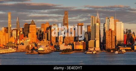 Golden-Hour-Blick auf die Skyline von Midtown Manhattan am Hudson River, New York City, USA. Wolkenkratzer und urbane Stadtlandschaft im warmen Sonnenuntergang Stockfoto
