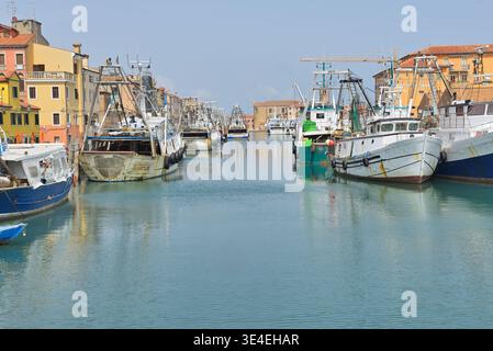 Alte Fischerboote liegen an einem schmalen Kanal in der historischen Hafenstadt Chioggia. Kopierbereich für Text. Stockfoto