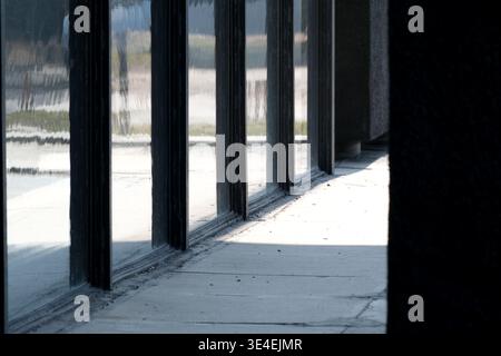 Reflexionen erzeugen ein kompliziertes Spiel von Licht und Schatten auf schlankem Fensterglas. Stockfoto