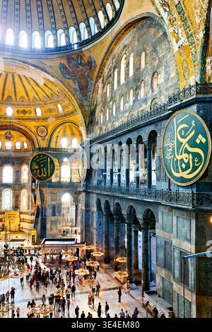 Viele Menschen laufen durch die Hagia Sophia Grand Moschee in Istanbul. Sie bewundern die Architektur und sehen die großen Dekorationen an den Wänden. Stockfoto