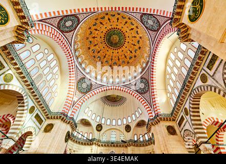 Besucher bewundern die großartige Architektur der Suleymaniye-Moschee in Istanbul, Türkei im Nachmittagslicht. Die Kuppel leuchtet mit komplizierten Details. Stockfoto