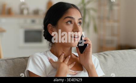 Verwirrte zögerliche indische arabische Frau zu Hause, die auf dem Handy spricht weibliche Käuferin, die über Probleme bei der Auftragslieferung spricht Stockfoto