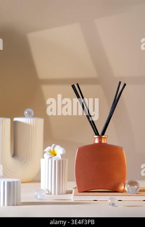 Reed-Diffusor mit Stäben auf beigefarbenem Hintergrund. Stockfoto