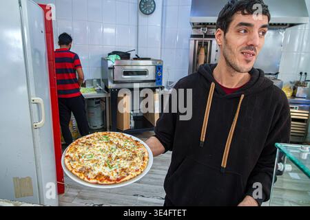Malaga Spanien, Andalusien, El Molinillo Capuchinos Nachbarschaft, Restaurant Küche Arbeiter Mann Erwachsener hält Pizzabeller Essen Service Angestellte Koch Werbung Stockfoto