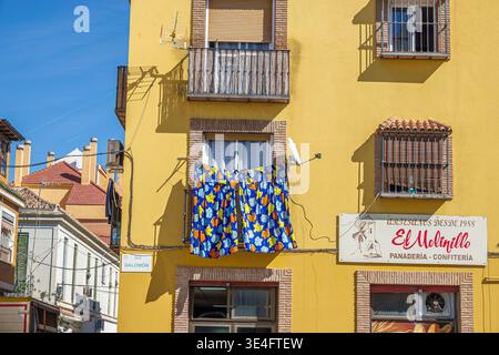 Malaga Spanien, Andalusien, El Molinillo Capuchinos Viertel, Calle Salomon Straßenschild Wohngebäude Fassade gelb außen Balkon Wäscherei hängen Stockfoto
