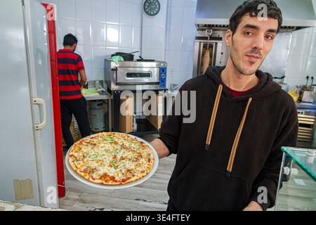 Malaga Spanien, Andalusien, El Molinillo Capuchinos Nachbarschaft, Restaurant Küche Arbeiter Mann Erwachsener hält Pizzabeller Essen Service Angestellte Koch Werbung Stockfoto