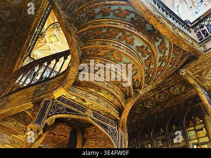 Livraria Lello, Innenansicht der Buchhandlung Lello mit reicher Dekoration der geschwungenen Holztreppe von unten, Porto, Portugal Stockfoto