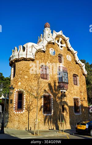 Besucher bewundern den Giebelgiebel des Märchenhauses im Park Güell, Barcelona. Das Gebäude besticht durch einzigartiges Design und historischen Charme. Stockfoto