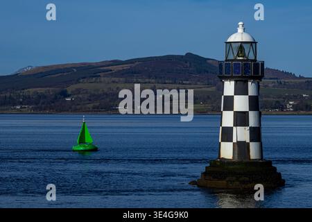 Der schwarz-weiße Leuchtturm steht im Kontrast zu weit entfernten sanften Hügeln und einem weiten, klaren Himmel über der schottischen Küste. Stockfoto