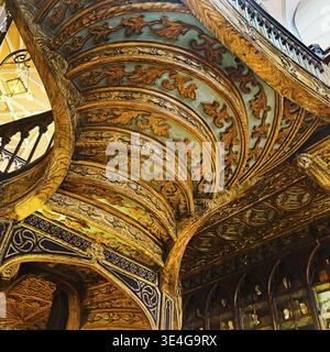 Livraria Lello, Innenansicht der Buchhandlung Lello mit reicher Dekoration der geschwungenen Holztreppe von unten, Porto, Portugal Stockfoto