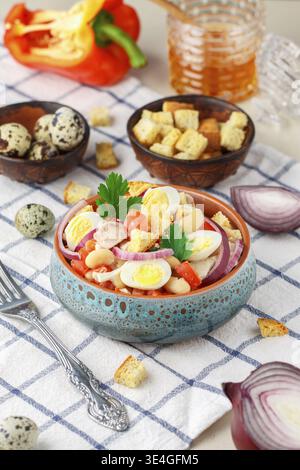 Essen, köstlicher Salat aus Hühnerfilet, Paprika, weiße Bohnen, Wachteleier, Brotcroutons, rote Zwiebeln und Petersilie mit einer Sauce aus Olivenöl, Mustar Stockfoto