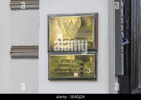 Blick auf die goldenen diplomatischen Tafeln an einer weißen Wand vor dem Gebäude der Royal Thai Botschaft. London, UK, 7. April 2024 Stockfoto
