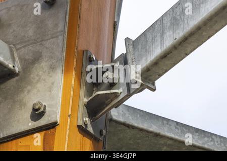 Nahaufnahme der Stahlhalterung, die eine Holzsäule und einen Balken aus Brettschichtholz verbindet Stockfoto
