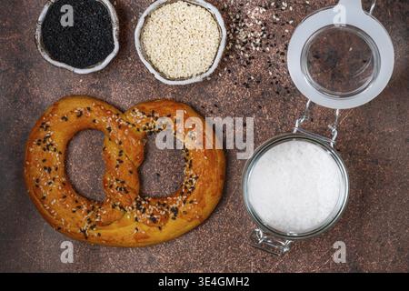 Essen, frisch gebackene hausgemachte Brezel mit schwarz-weißem Sesam und grobem Meersalz. Deutsche (bayerische) Biervorspeise. Selektiver Fokus Stockfoto