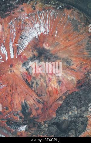 Detaillierte Luftaufnahme einer massiven Müllhalde mit extremer Bodenerosion und farbenfrohen Mineralschichten. Diese Industrielandschaft veranschaulicht die nachhaltigen Umweltauswirkungen des Bergbaus und natürlicher Oxidationsprozesse im Winter. Stockfoto