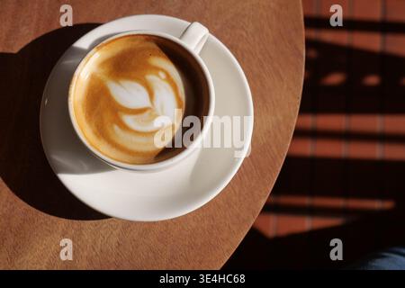 Kaffeetasse auf dem Tisch mit Kaffeekunst-Design Stockfoto
