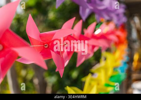 Farbenfrohe Plastikräder, die sich im Wind drehen, bei Tempeldekoration in Thailand Stockfoto